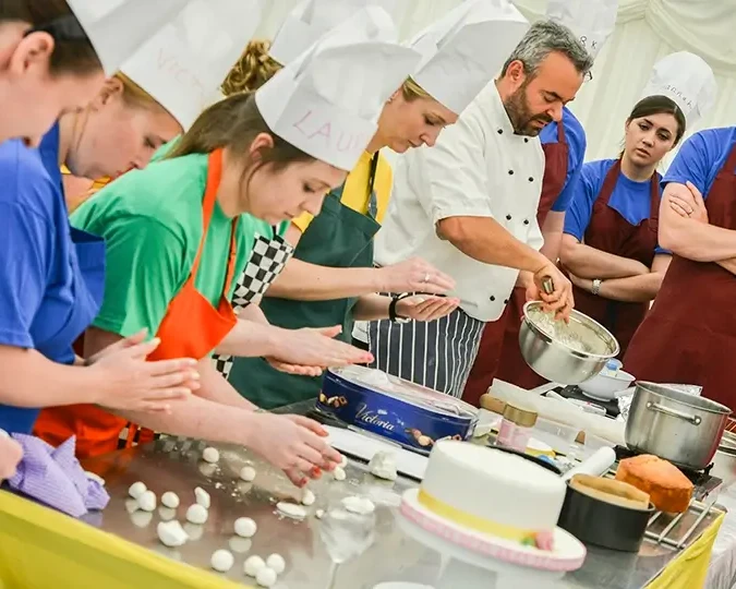 team building participants in baking challenge guided by pastry chef