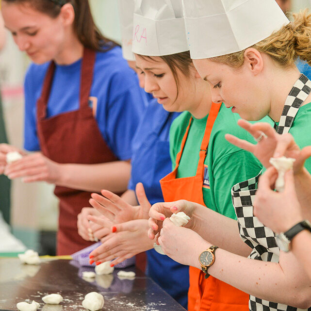Colleagues rolling icing in their hands during a Bakeathon team building event