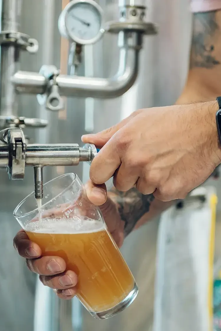 Man pouring a glass of beer for participants to taste