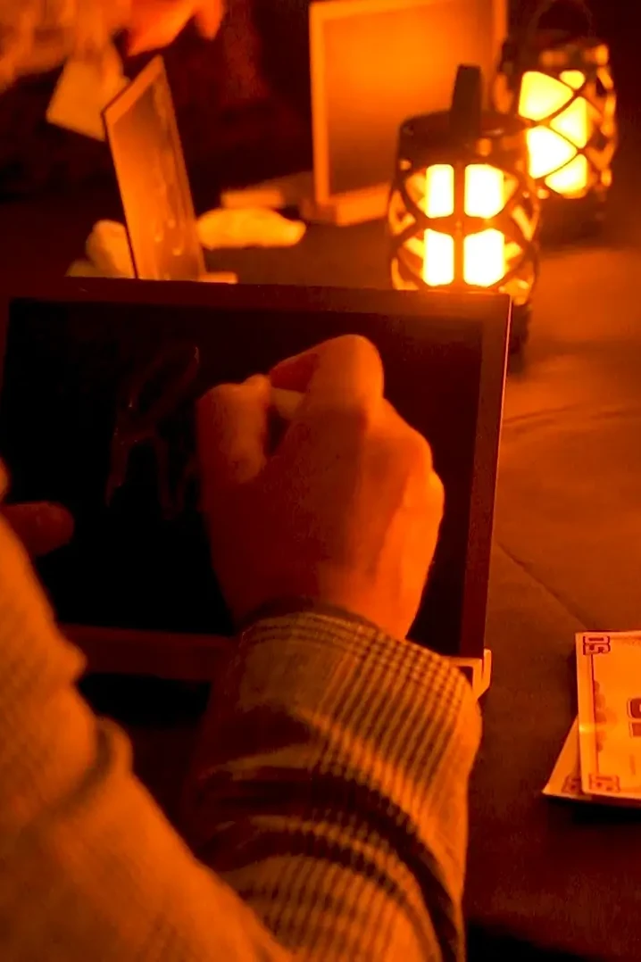 Traitors team building participant writing name on the slate around the table in the castle