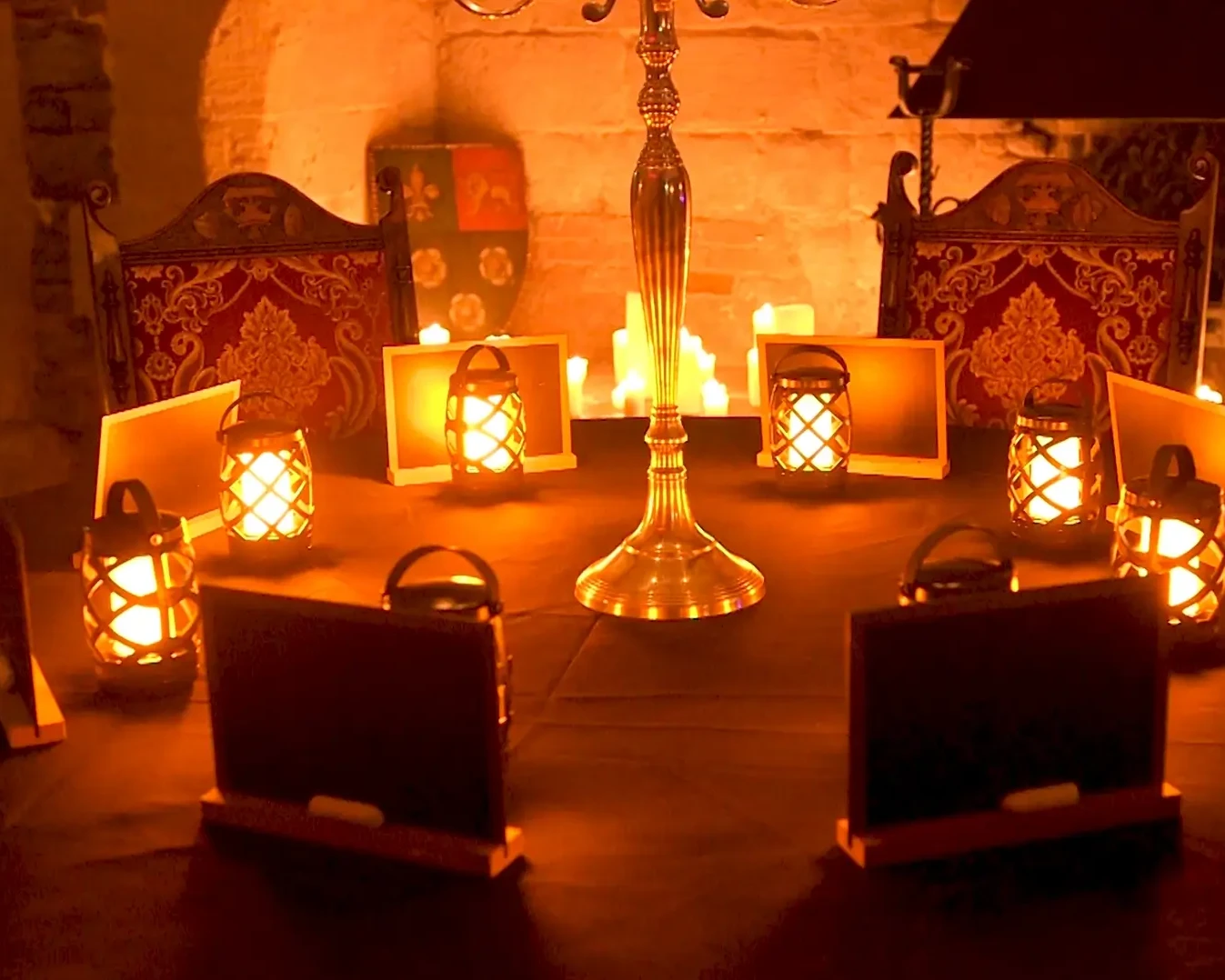 Traitors team building activity with slates and lanterns in a dark, castle room