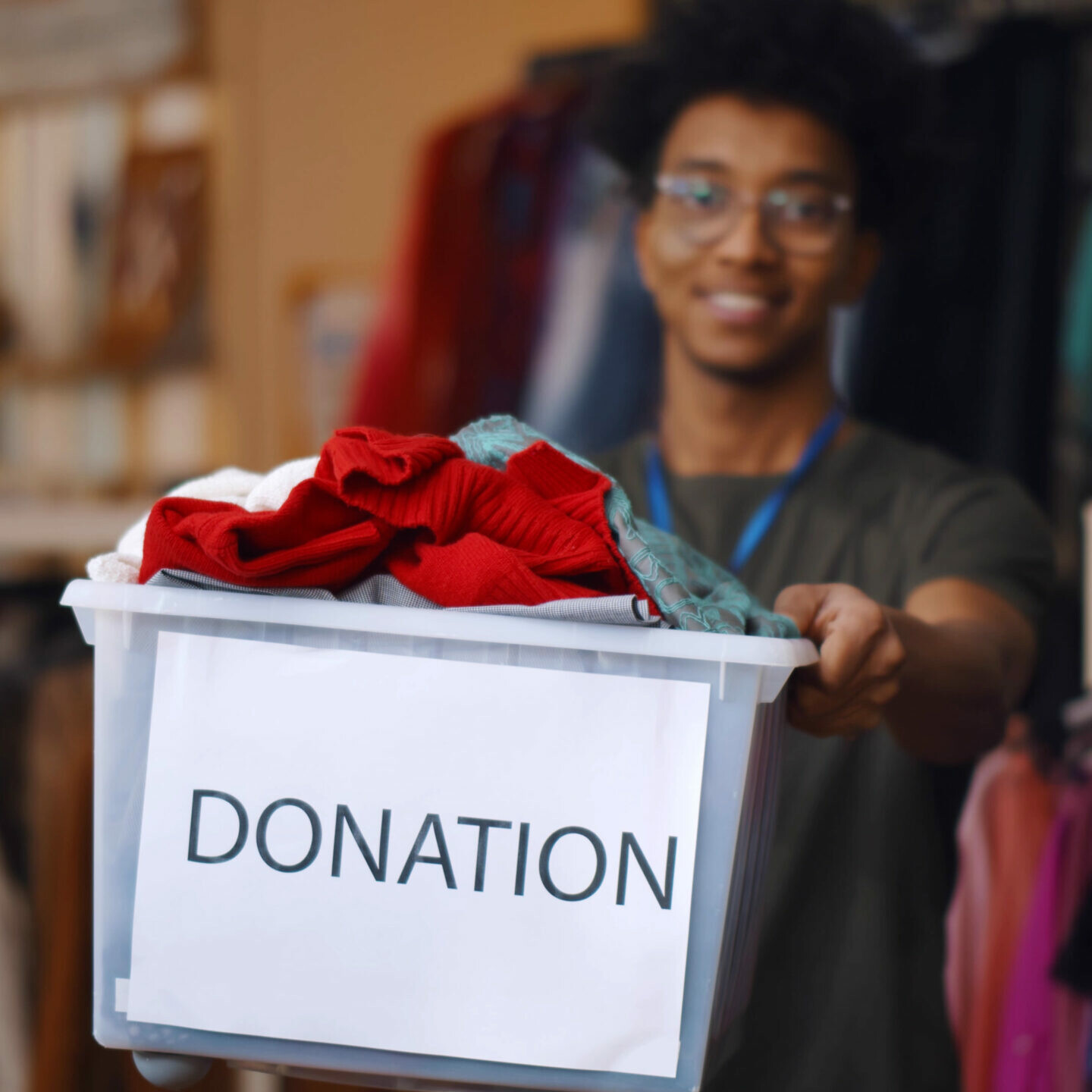 Man donating clothing in a box that says 