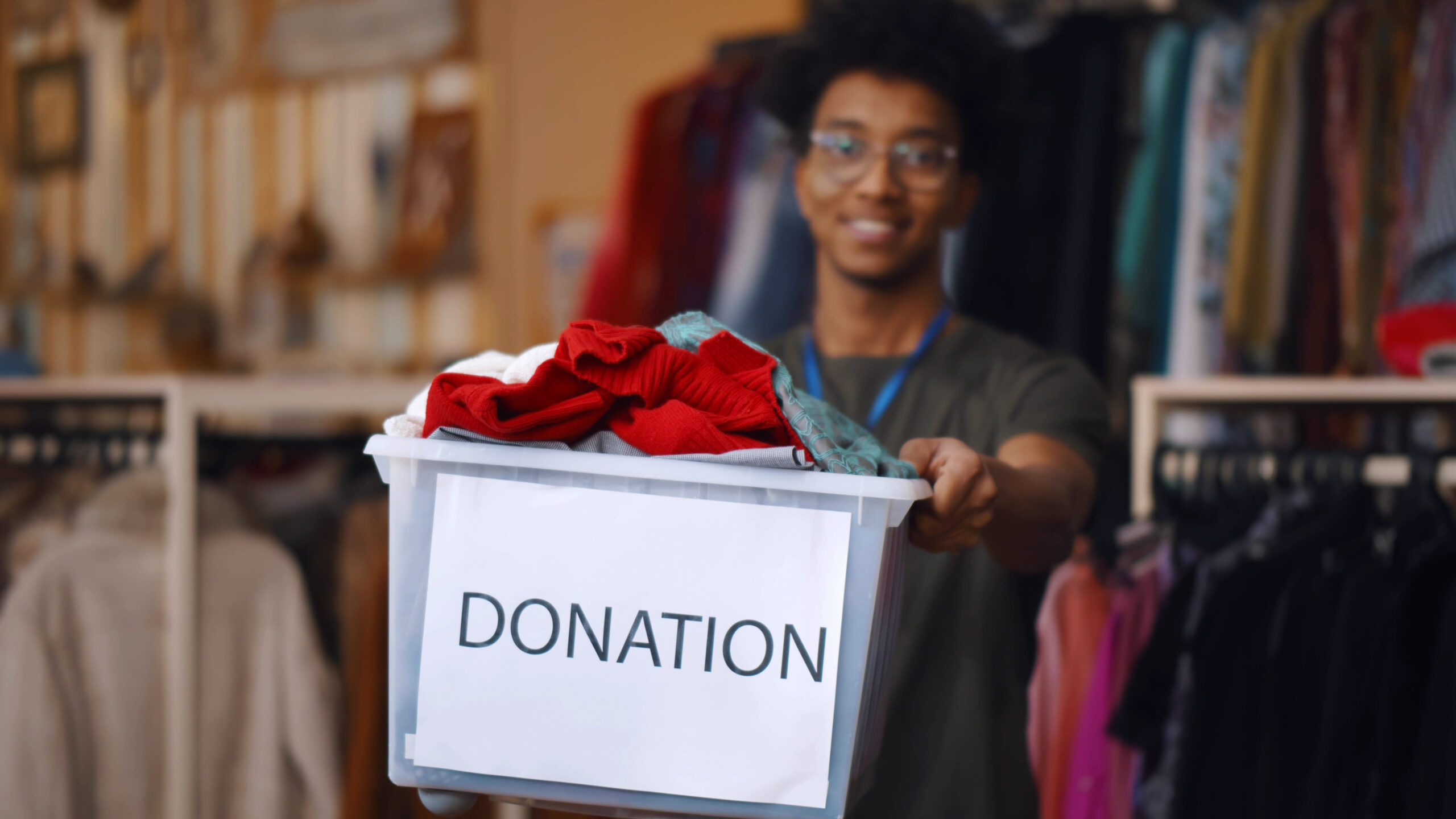 Man donating clothing in a box that says 