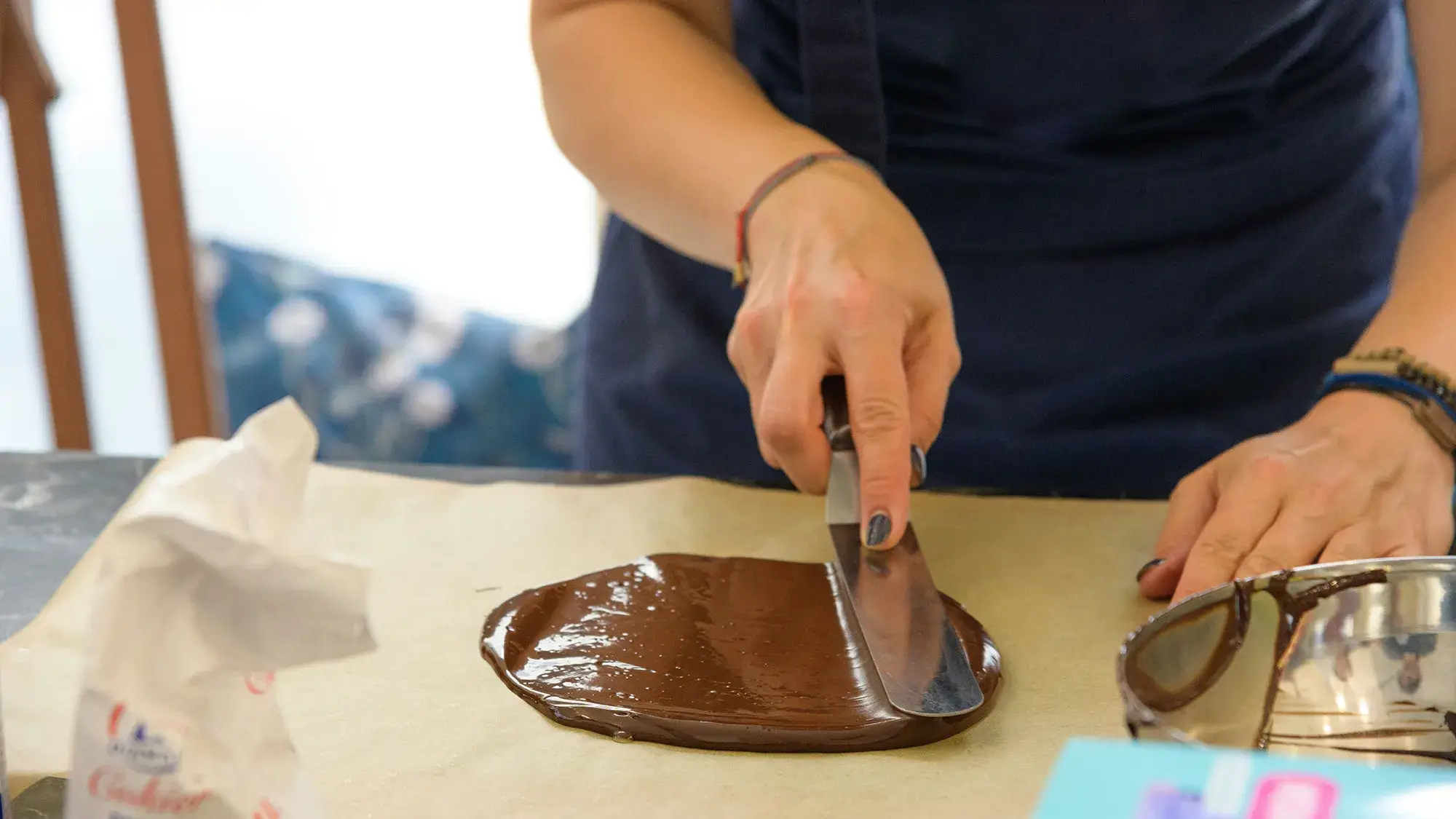 close-up in hand spreading chocolate on paper in cookery team building event