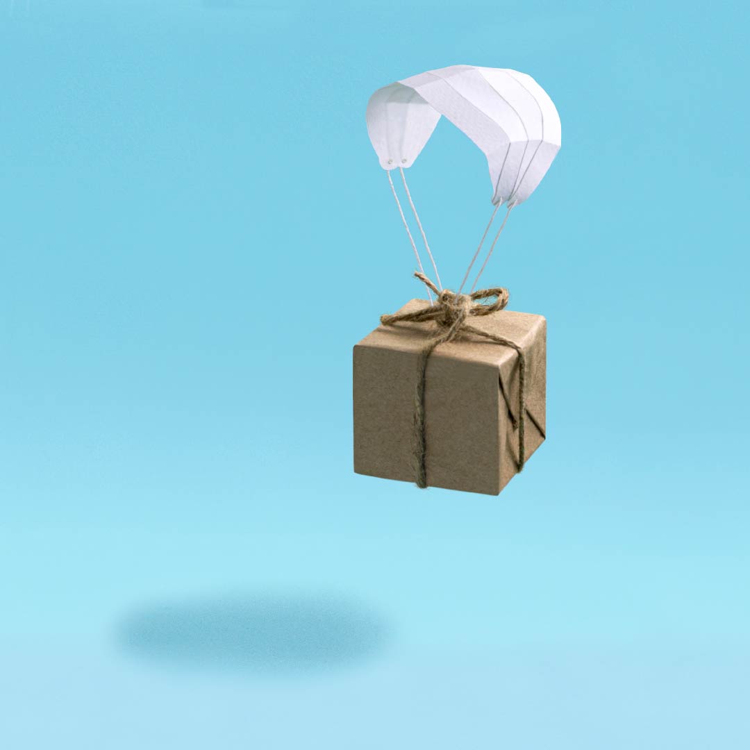 Brown paper parcel held up by a white parachute.