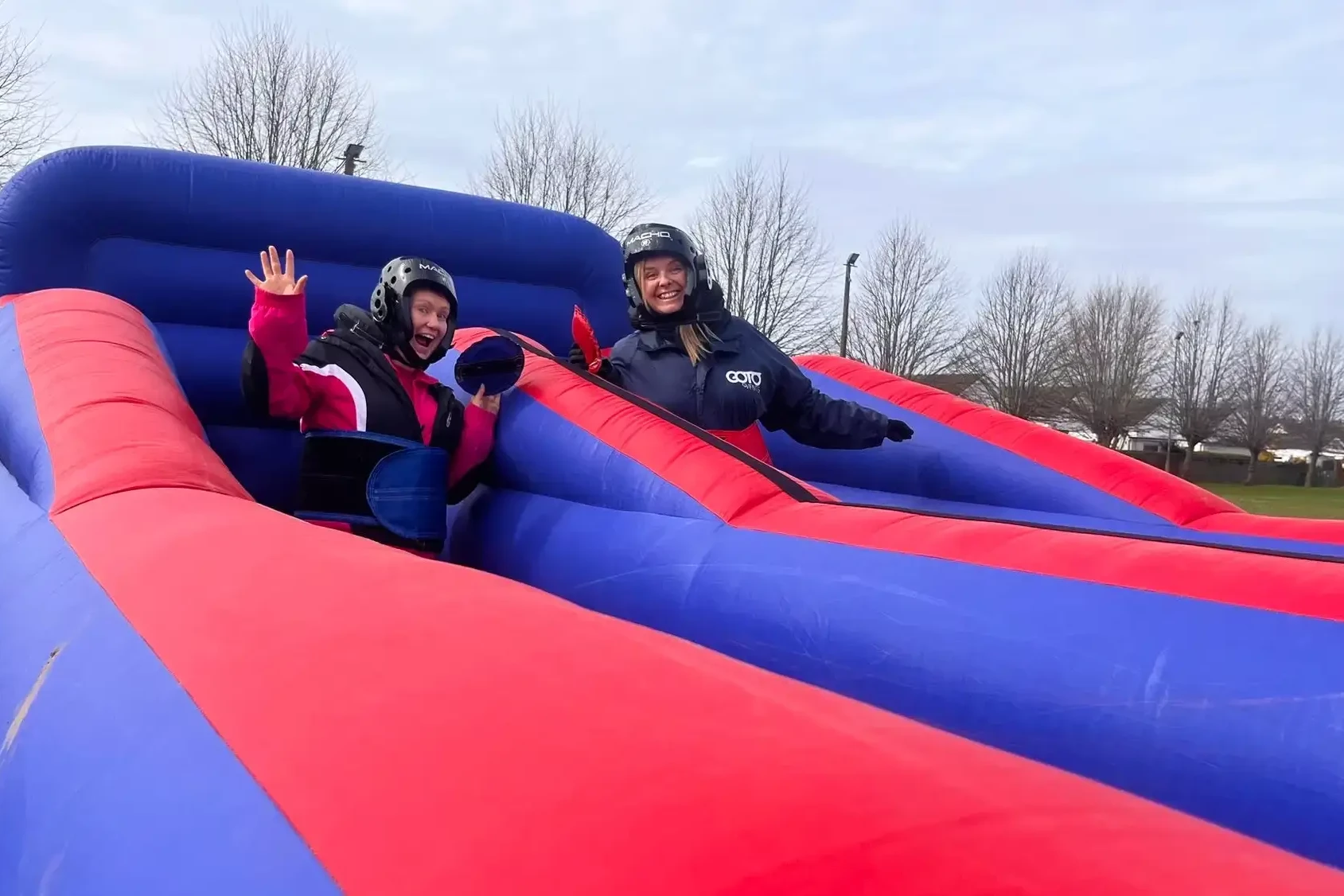 people having fun on slippery slides in outdoor team building event