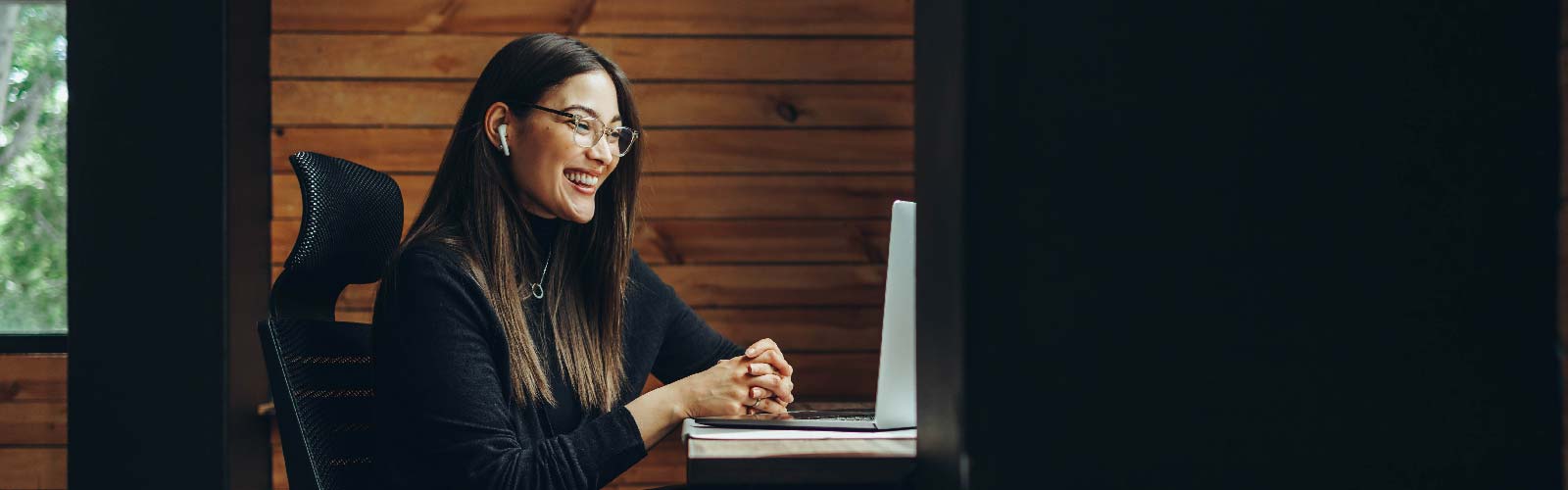 Woman smiling at her screen during a call on a virtual event