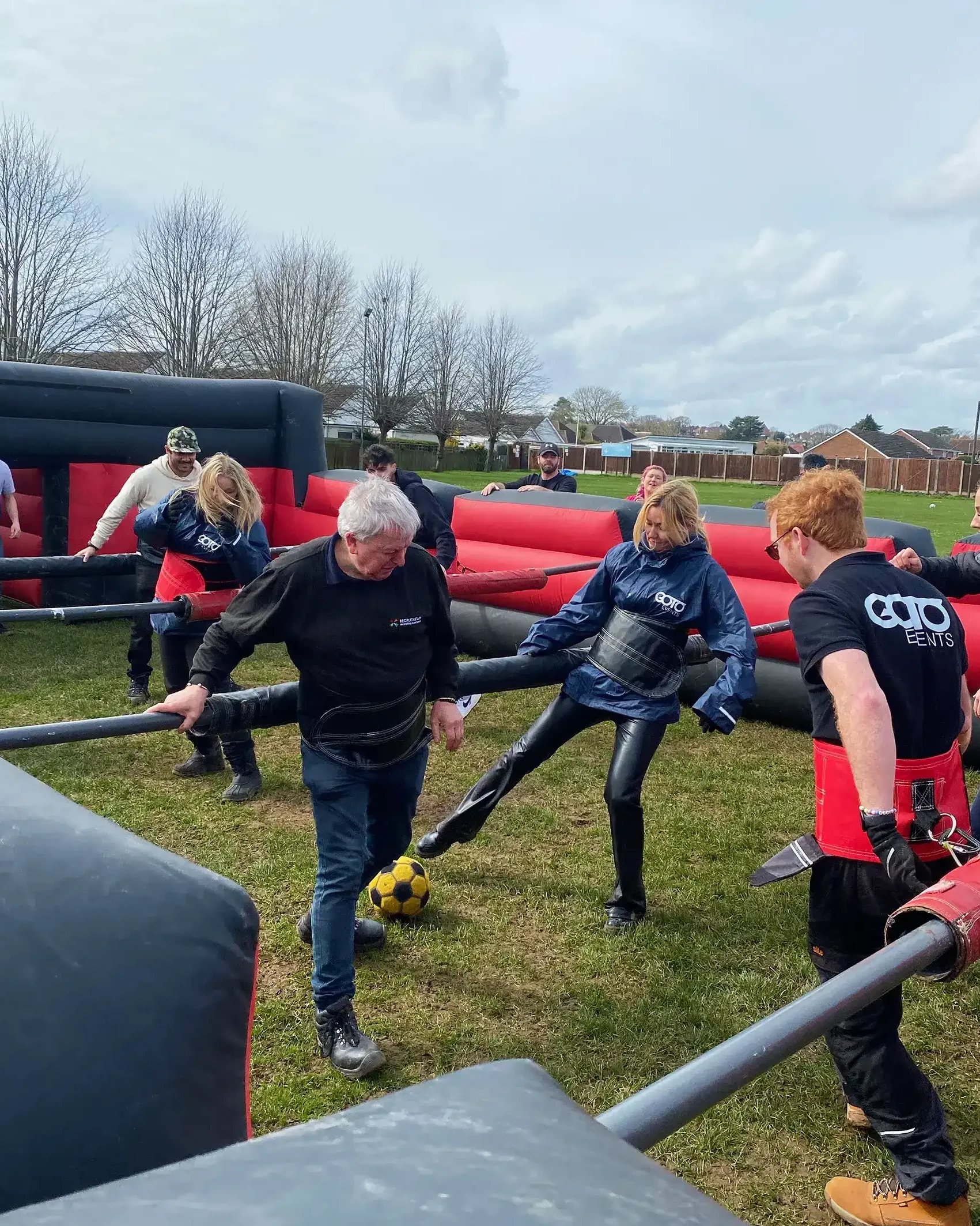 Teams playing human football table on company sports day event