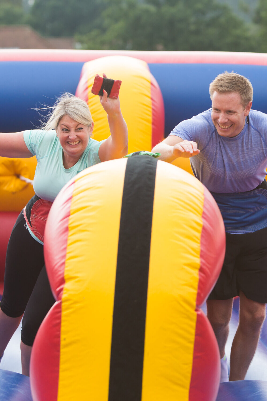 People having fun while competing in team building competition on inflatable course