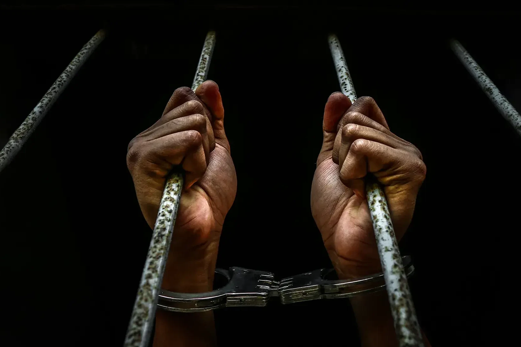 prison bars and hands symbolising Jailbreak team building activity