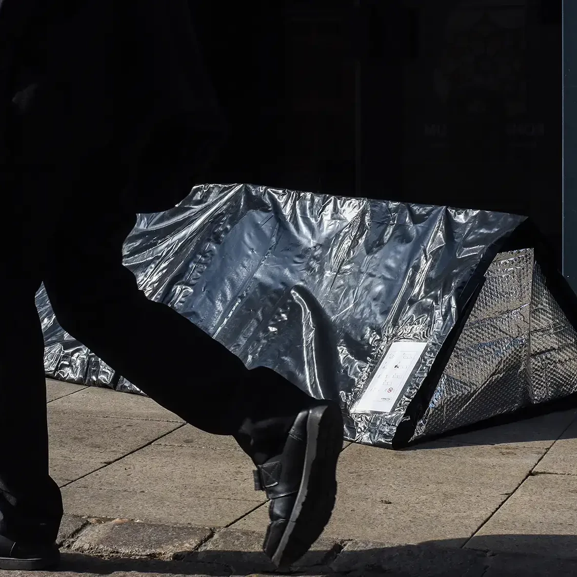 Man walking on street with sleep walk on the floor in the background