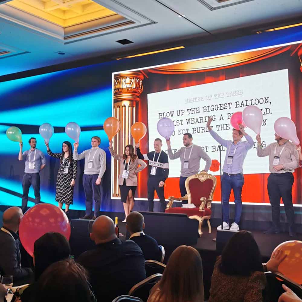 Colleagues stood on a stage with balloons in their hands