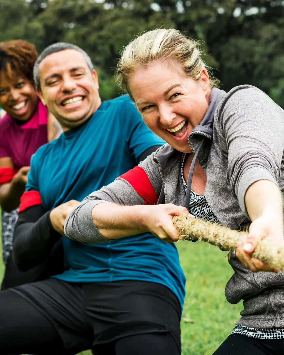 People pulling on rope in tug of war finale at sports team building event