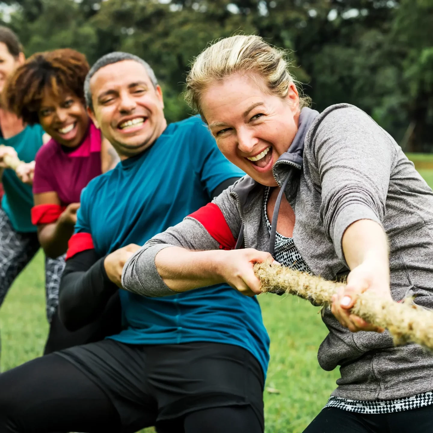 People pulling on rope in tug of war finale at sports team building event