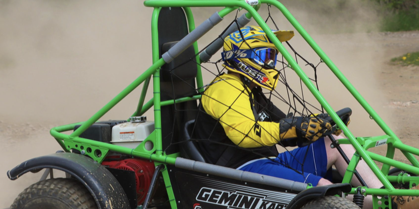 Person with helmet inside green Off Road Buggy in outdoor team building fun