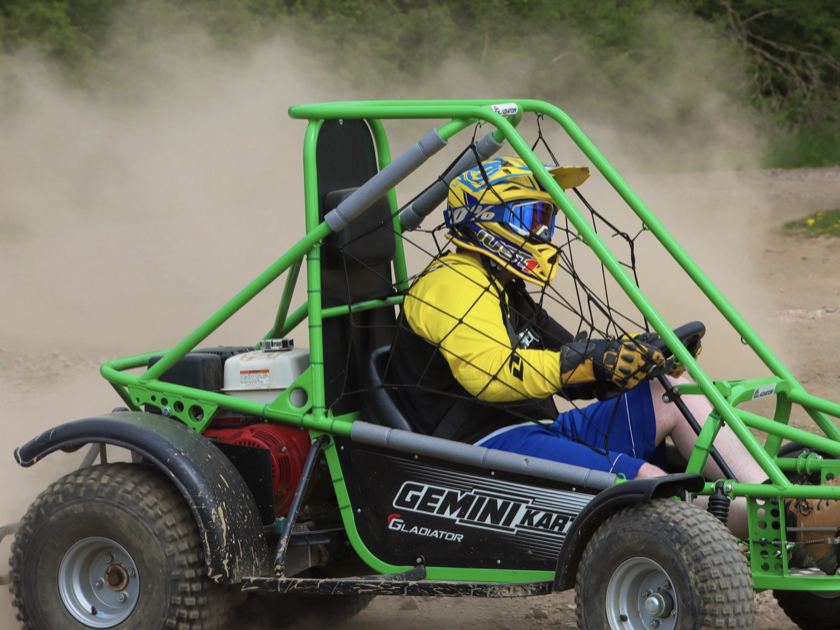 Person with helmet inside green Off Road Buggy in outdoor team building fun