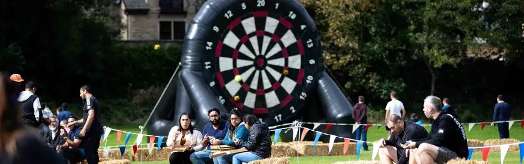 Giant inflatable target at outdoor event with team getting ready to play archery