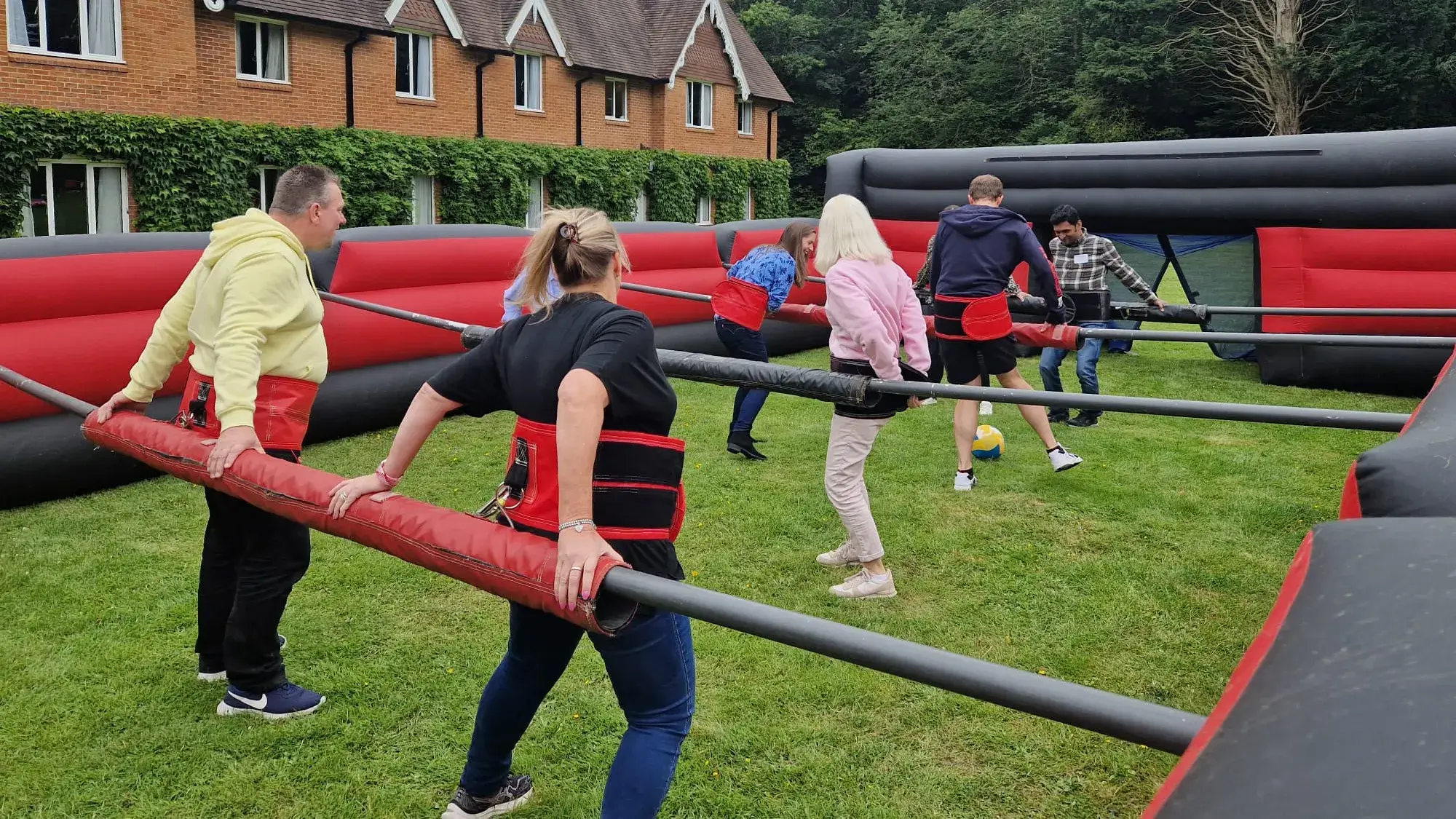 People playing in giant table football team building activity outdoors