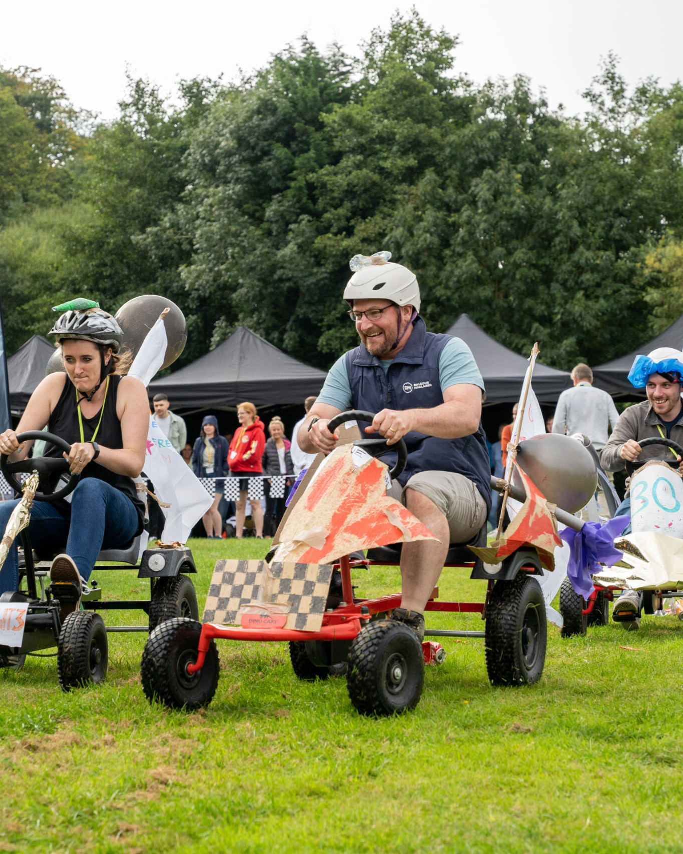 funny race on colourful carts during outdoor team building event