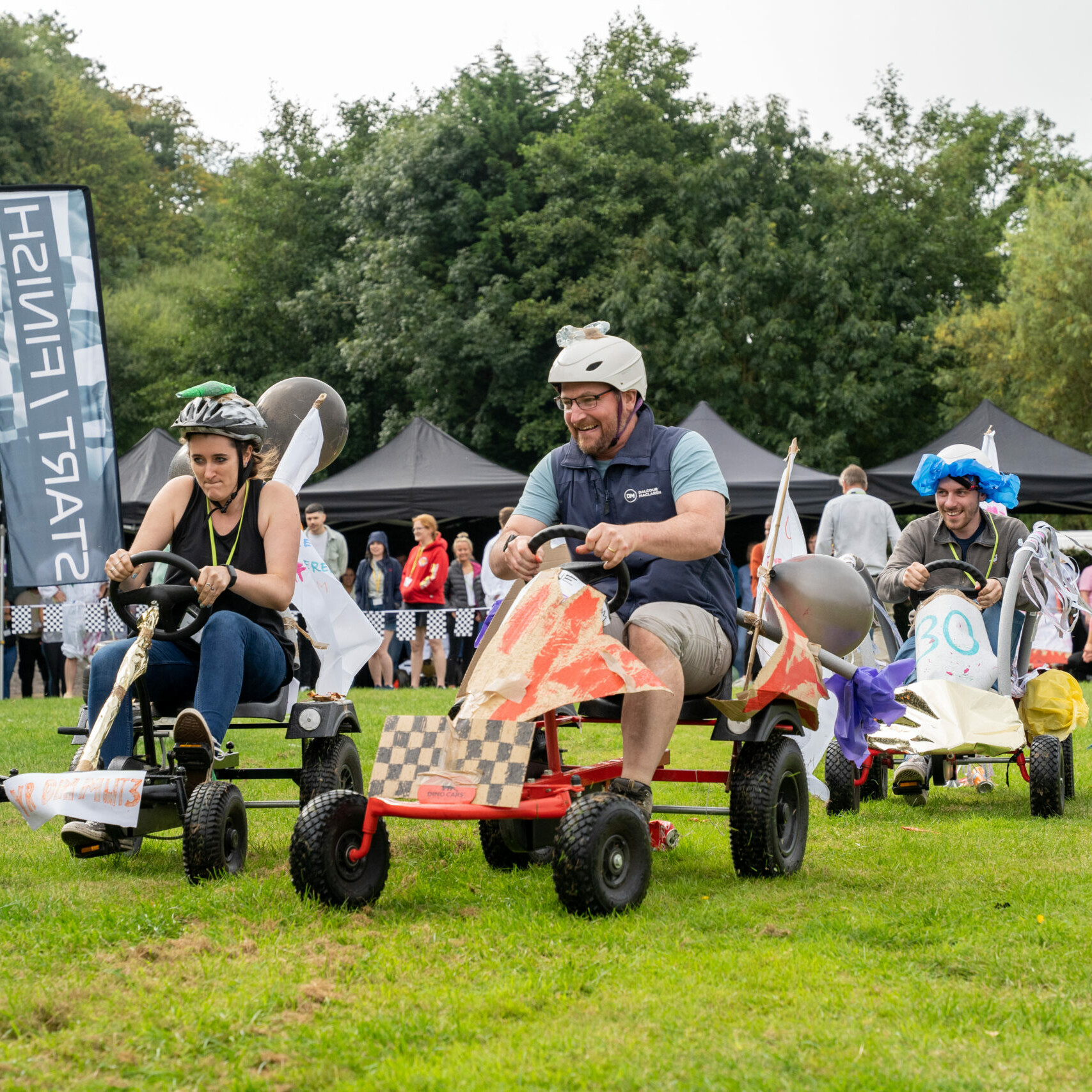 funny race on colourful carts during outdoor team building event