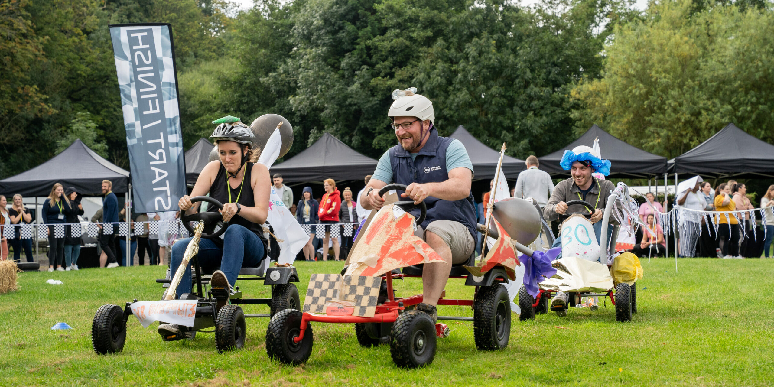 funny race on colourful carts during outdoor team building event