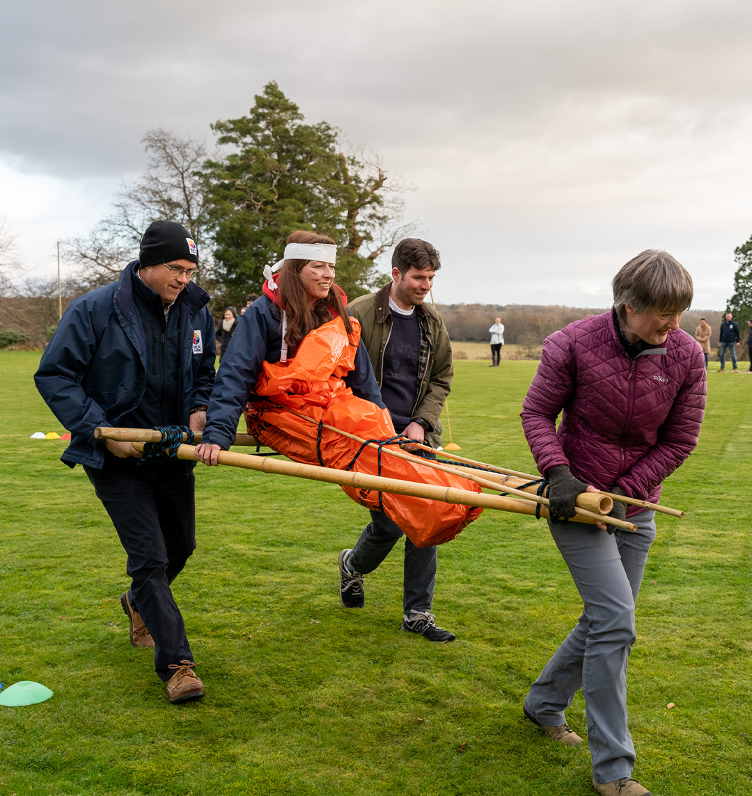 Women being carried by team in survivor island team building event for summer