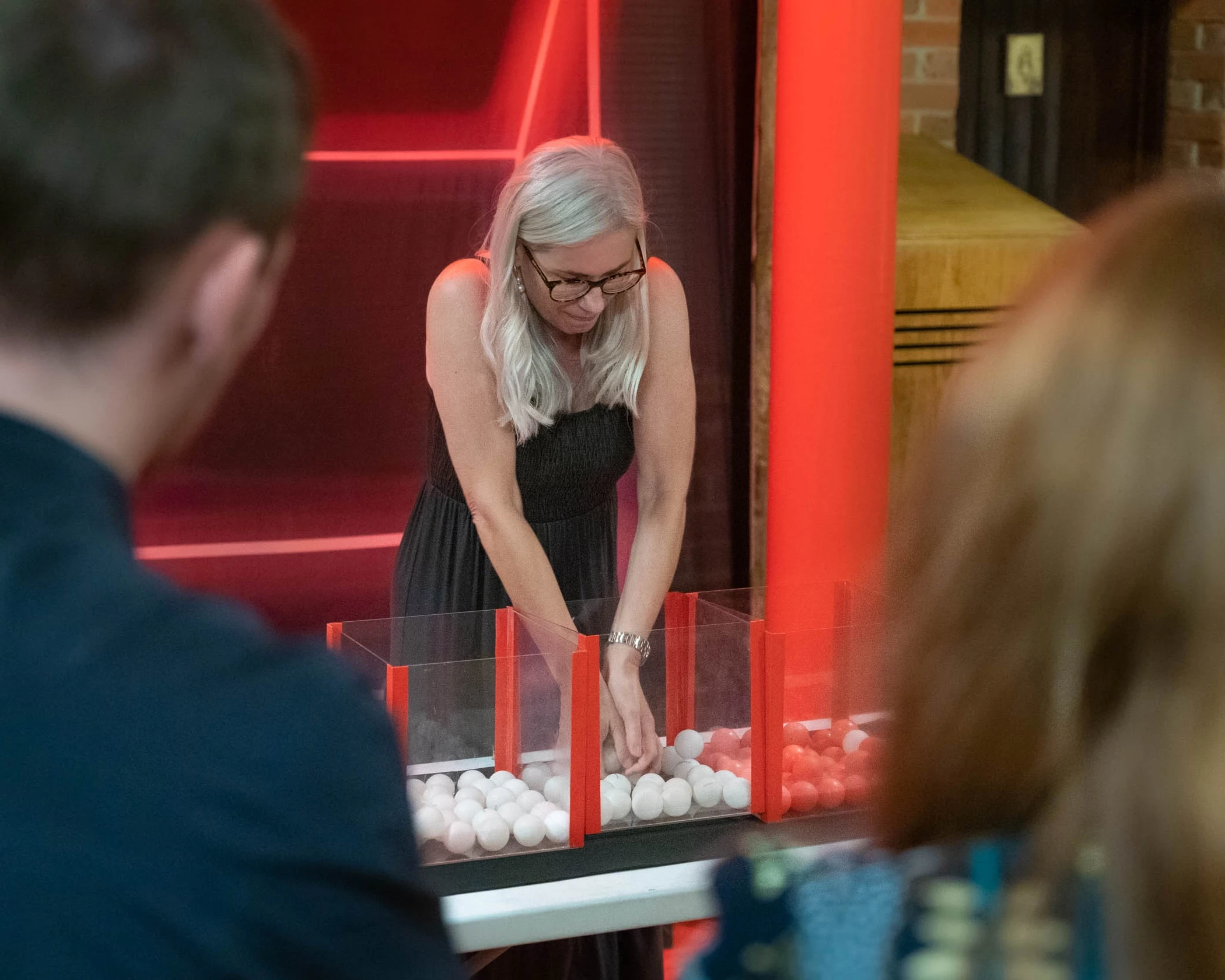 A woman separating coloured balls during an Under Pressure team building game