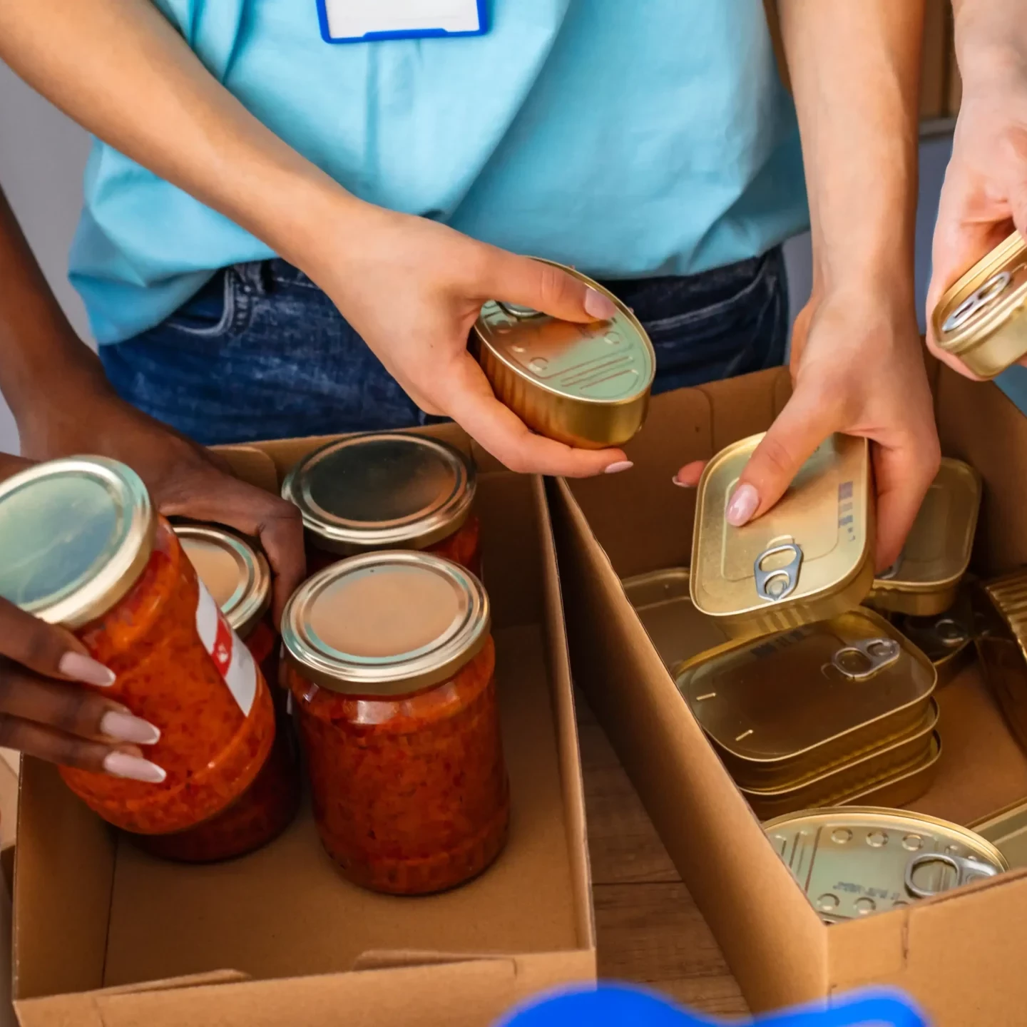 people putting together care packages with cans and jars of food in charity team building event