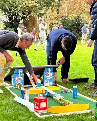 people building mini gold hole with cereal boxes in charity team building event