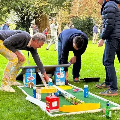 people building mini gold hole with cereal boxes in charity team building event