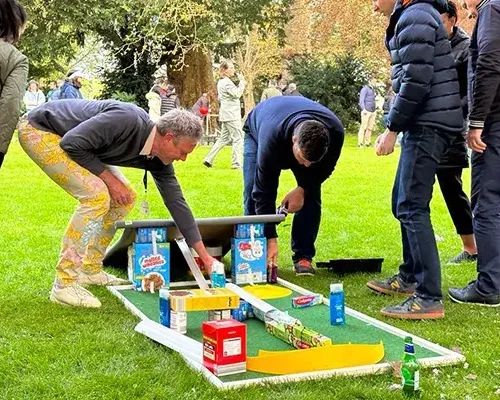 people building mini gold hole with cereal boxes in charity team building event