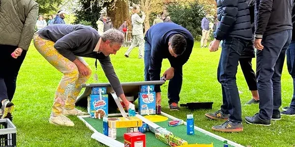 people building mini gold hole with cereal boxes in charity team building event