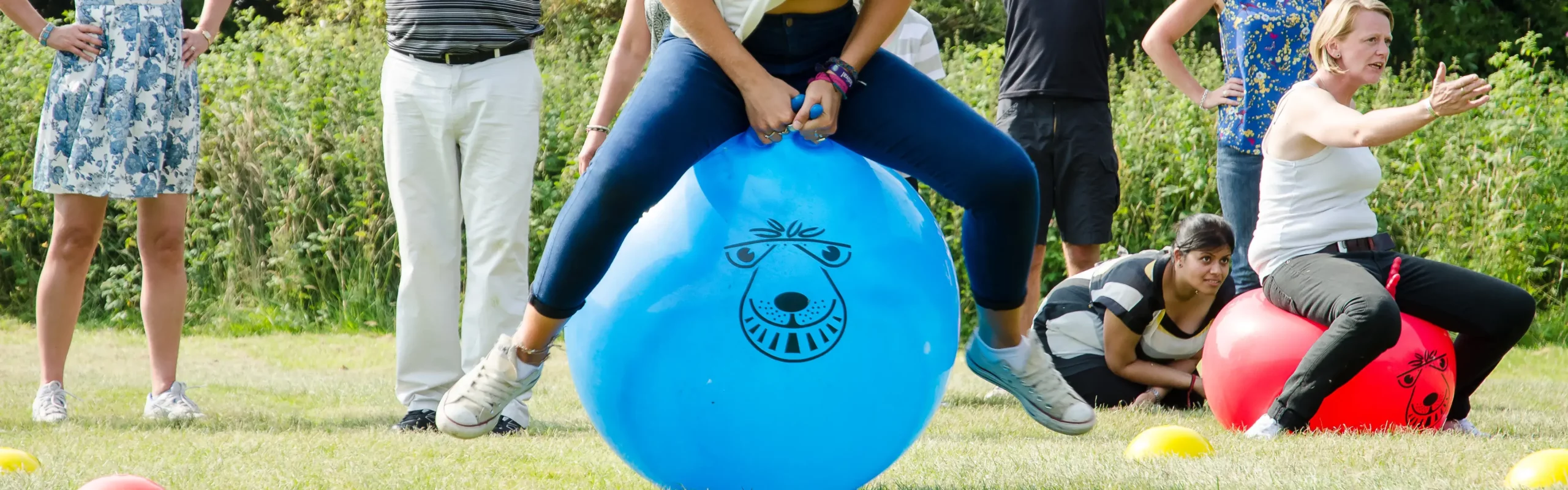 women jumping on blue space hopper in team building event