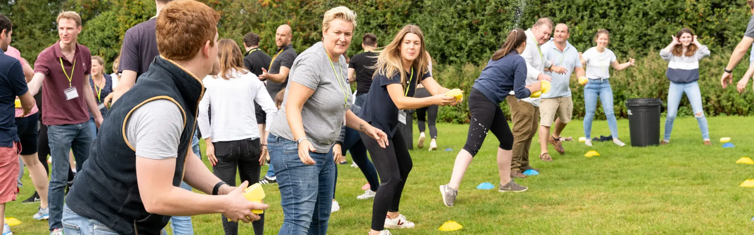 Group of people taking part in Olympic-inspired shot put team building outdoor