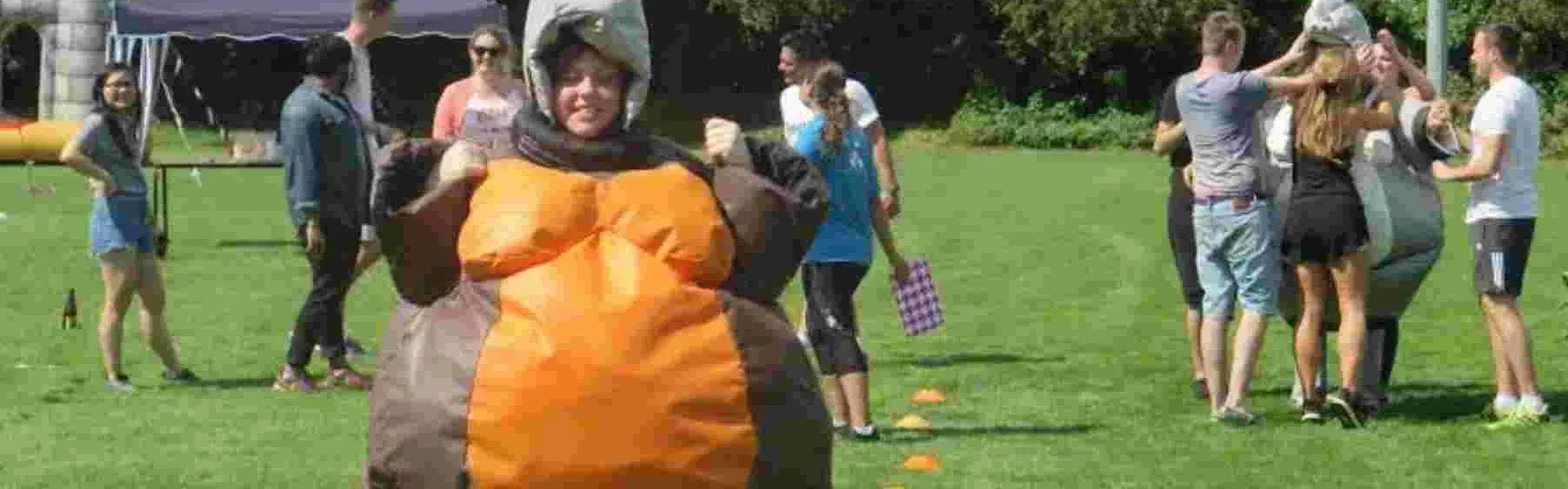 Team member in inflatable sumo costume for Olympic-inspired team building sports day