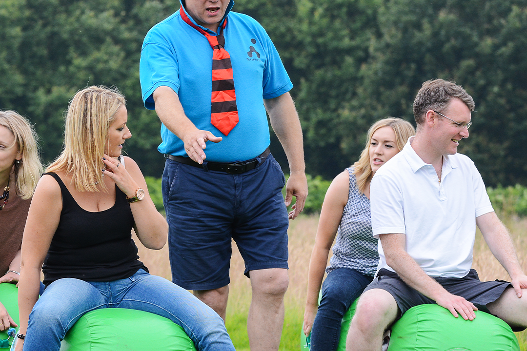 people sitting on green space hoppers for school sports day team building event outdoors