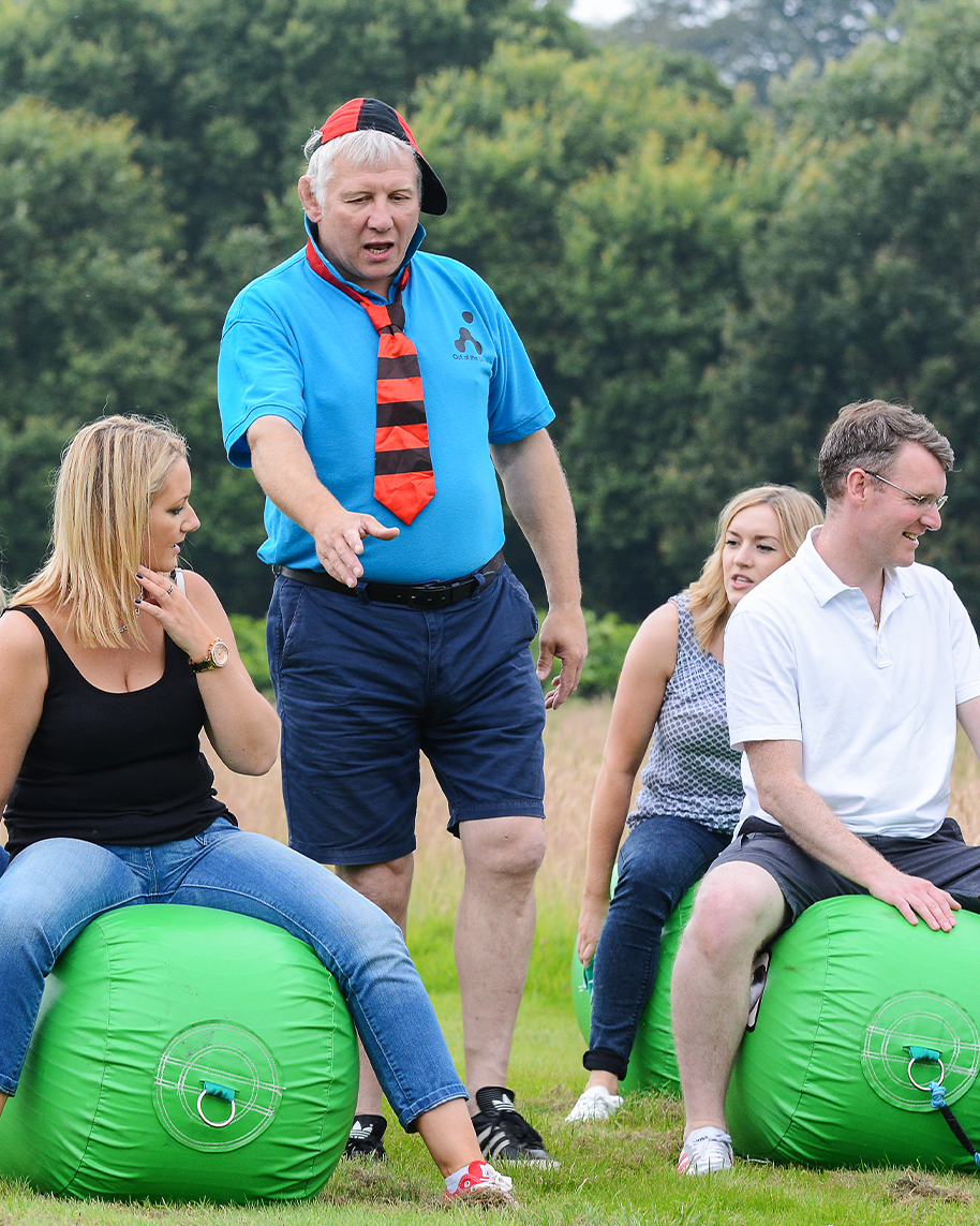 people sitting on green space hoppers for school sports day team building event outdoors