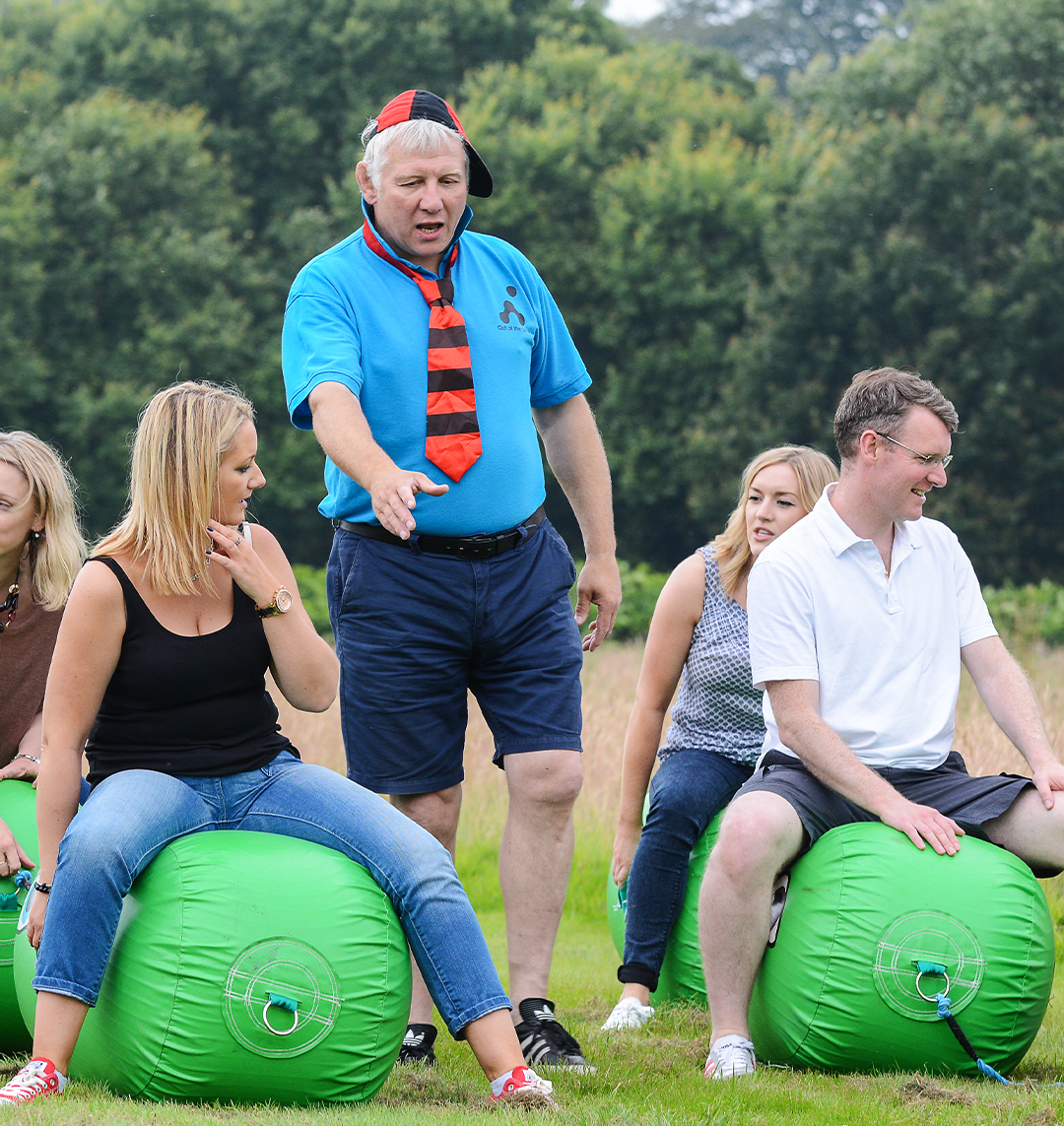 people sitting on green space hoppers for school sports day team building event outdoors