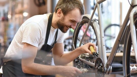 Man oiling a chain on bike build team building