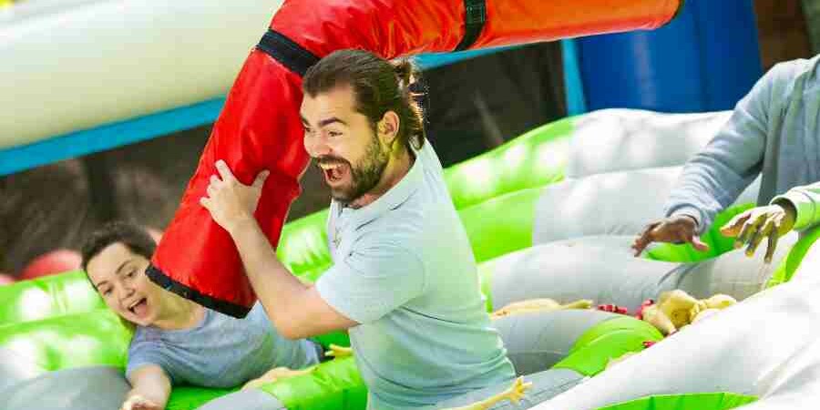 People laughing in inflatable team building event held outdoors in the summer