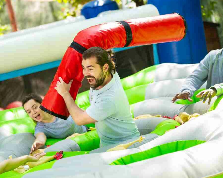 People laughing in inflatable team building event held outdoors in the summer