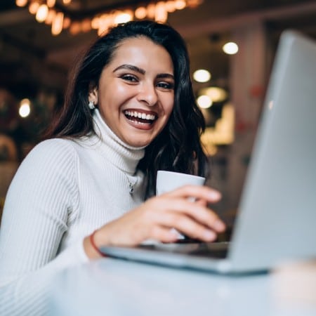 Lady on laptop virtual team building smiling