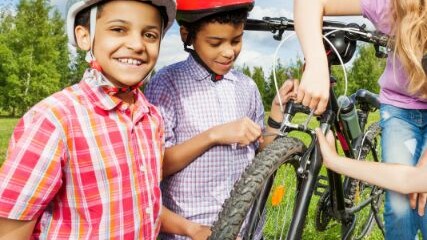 Two boys and mum repairing a bike