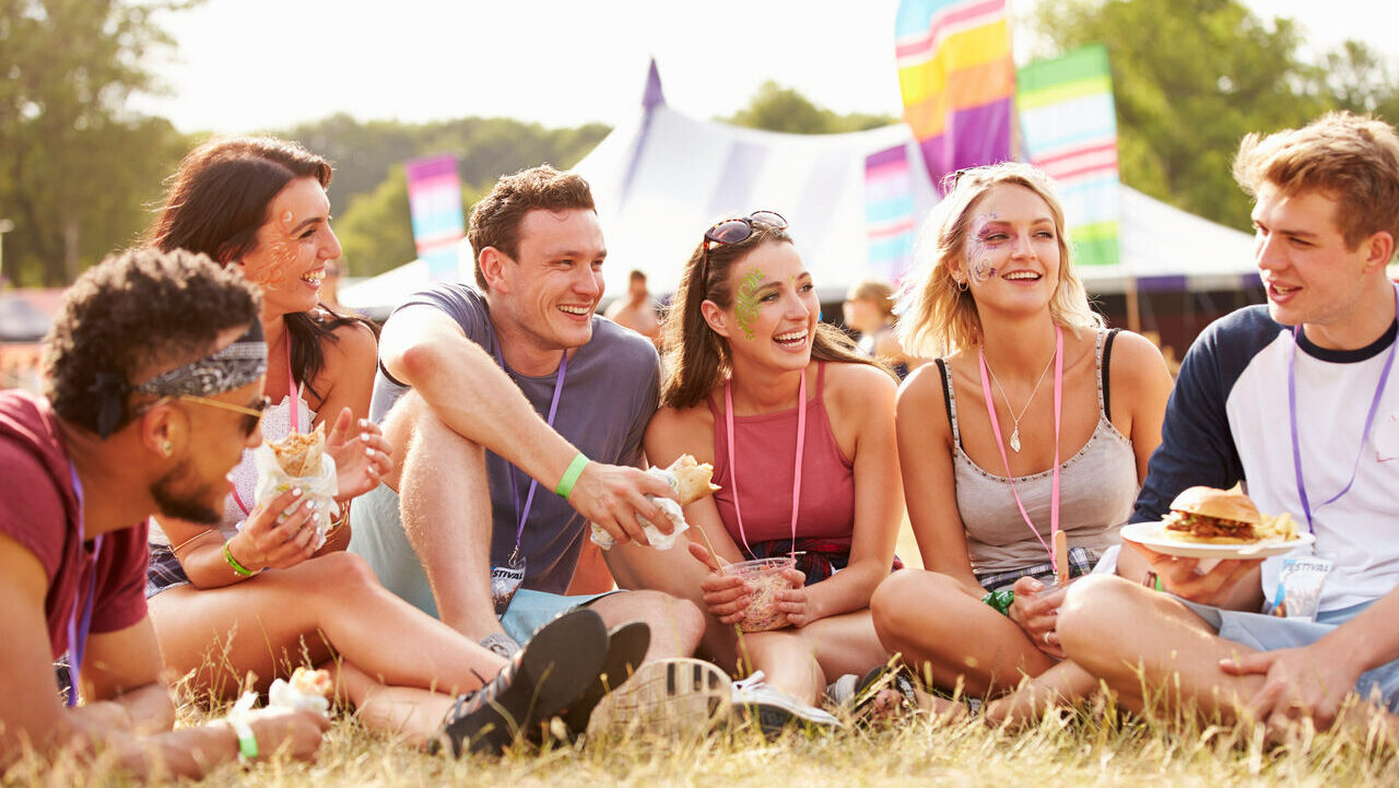 Group of 5 people sitting and laughing at a company away day festival