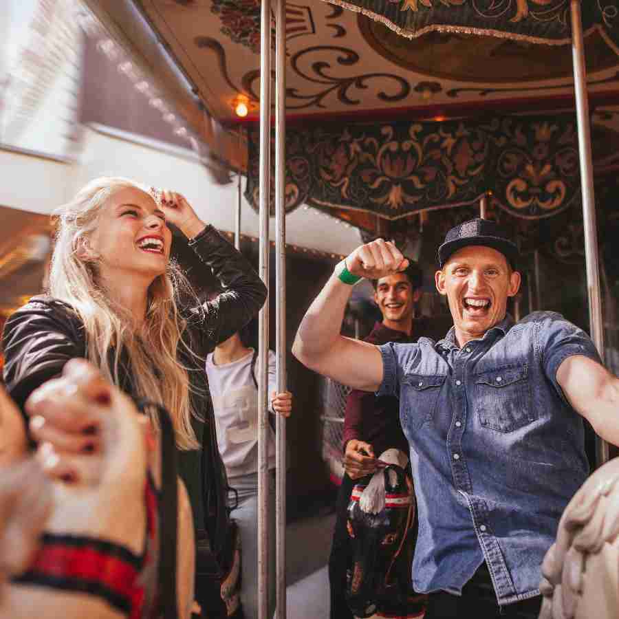 Adults smiling on a carousel on a company fun day