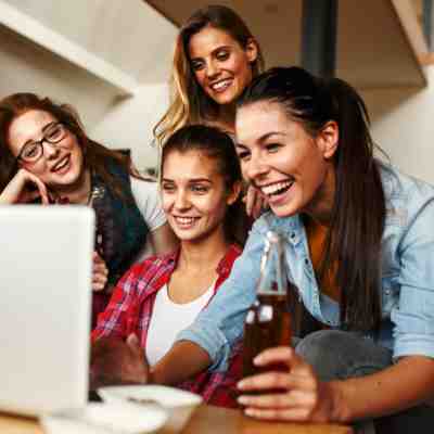 Virtual Christmas party people laughing round a laptop