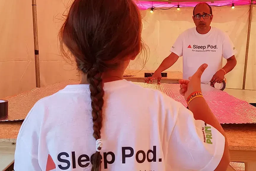 Sleep Pod charity staff wearing white t-shirts with charity logo while building sleep pod