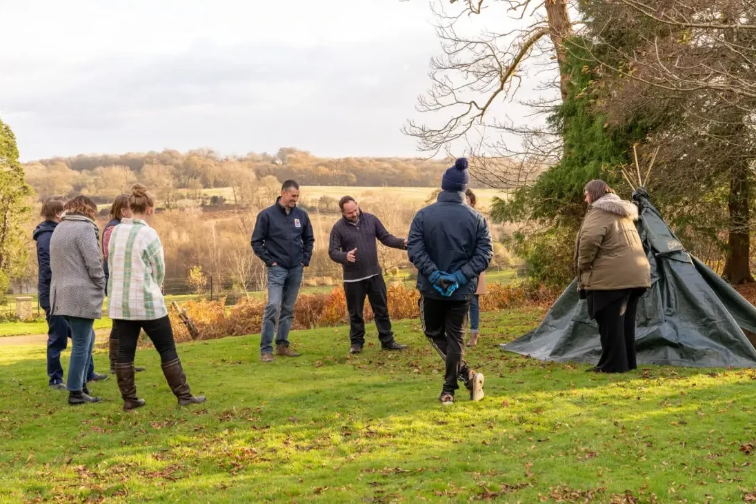 teams building a den in outdoor team building event