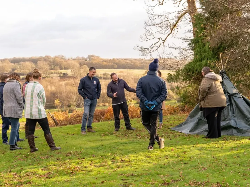 teams building a den in outdoor team building event